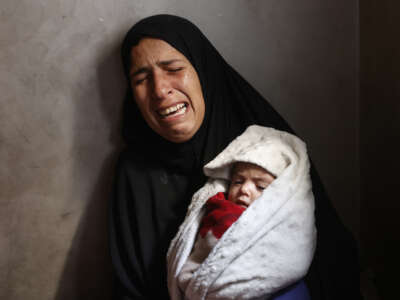 Hiba Abu Jarad, 30, mother of three-month-old Palestinian baby Shatha Abu Jarad, who died of cold weather according to medics, cries while holding Nada, Shatha's twin sister, in Gaza City, Gaza, on January 20, 2026.