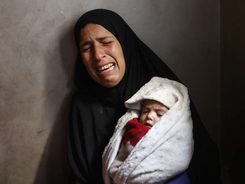Hiba Abu Jarad, 30, mother of three-month-old Palestinian baby Shatha Abu Jarad, who died of cold weather according to medics, cries while holding Nada, Shatha's twin sister, in Gaza City, Gaza, on January 20, 2026.