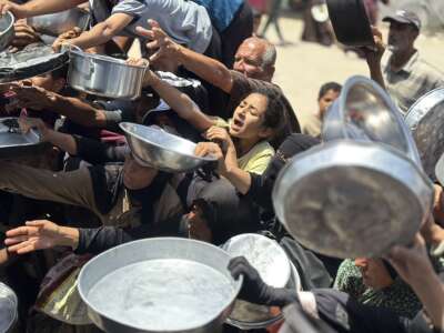 Displaced Palestinians crowd around a food distribution point at Al-Saada charity kitchen in Al-Mawasi, Khan Younis, in the Gaza Strip, on May 13, 2026. Residents fear worsening living conditions and a renewed risk of famine as food aid declines across the Gaza Strip.
