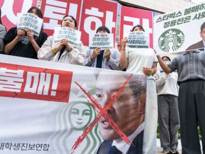 Protesters hold placards reading “Boycott Starbucks” and “resignation of Chung Yong-jin” in front of the Starbucks Korea headquarters in Seoul, South Korea, on May 23, 2026.