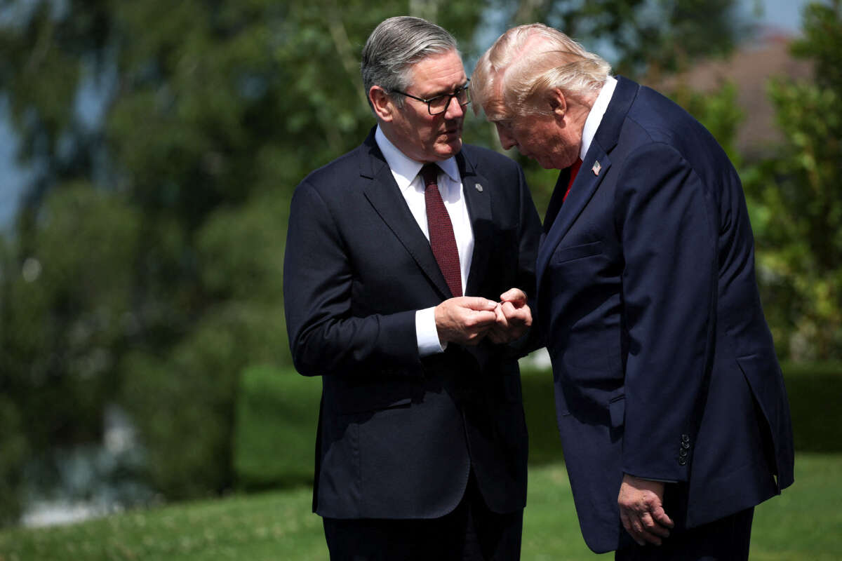 U.S. President Donald Trump and British Prime Minister Keir Starmer speak as they wait for a family photo during the G7 summit on June 16, 2026, in Evian-les-Bains, France.
