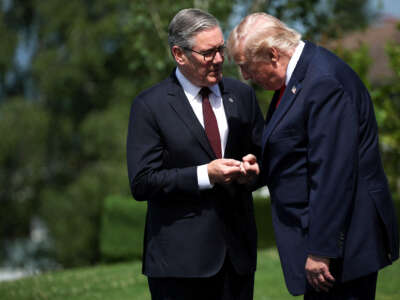 U.S. President Donald Trump and British Prime Minister Keir Starmer speak as they wait for a family photo during the G7 summit on June 16, 2026, in Evian-les-Bains, France.