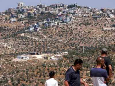Palestinian men look at a newly-established Israeli settler outpost near the village of Jurish, south of Nablus in the occupied West Bank, on June 20, 2026.