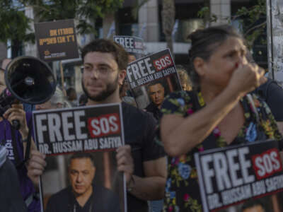 Israeli left-wing activists hold placards and chant slogans in Tel Aviv, on July 6, 2026, during a rally calling for release of Palestinian Doctor Hussan Abu Safiya, detained by Israeli forces since December 2024.