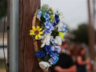 A floral wreath hangs on a utility pole near the intersection of Wayside Drive and Canal Street in Houston, Texas, on July 7, 2026, marking the location where Lorenzo Salgado Araujo was fatally shot by an ICE agent.