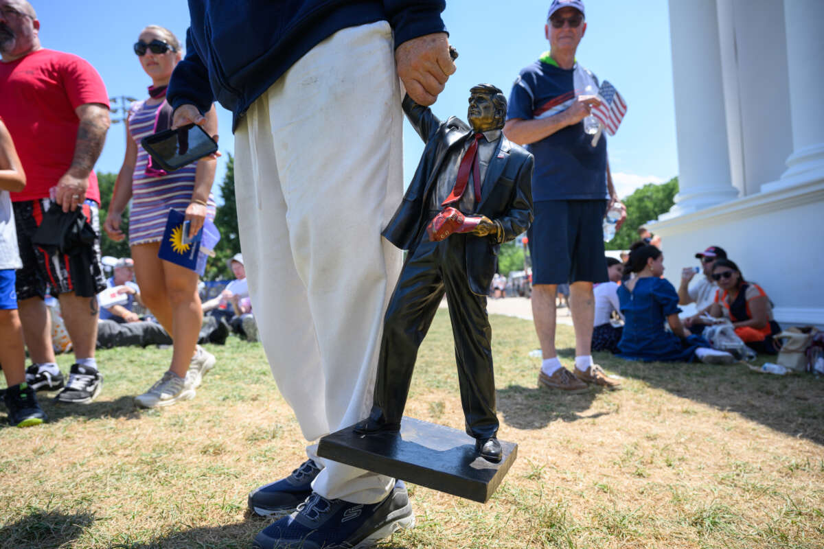 A person carries a miniature statue of President Donald Trump at The Great American State Fair along the National Mall on July 4, 2026, in Washington, D.C.