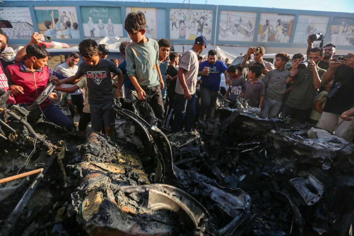 People inspect a car that was destroyed by Israeli air strikes on July 8, 2026, in Gaza City, Gaza.