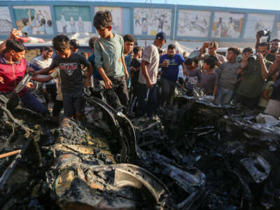 People inspect a car that was destroyed by Israeli air strikes on July 8, 2026, in Gaza City, Gaza.