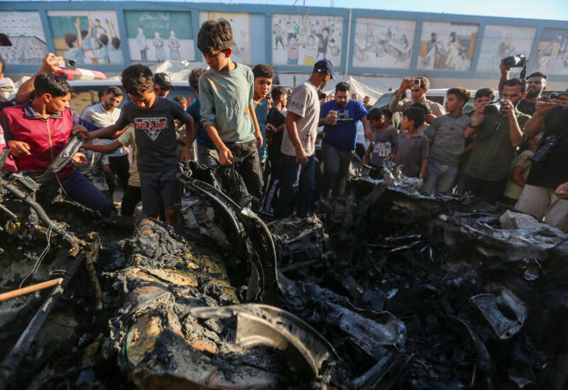 People inspect a car that was destroyed by Israeli air strikes on July 8, 2026, in Gaza City, Gaza.