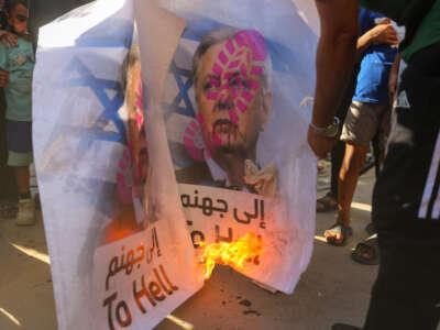 Palestinian refugees burn a picture of Lindsey Graham during a demonstration outside the Al-Shati camp food distribution center, a UNRWA facility, on July 15, 2026, in Gaza City, Gaza.