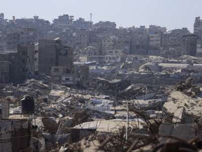 A wide view shows makeshift tents and shelters spread among extensively destroyed buildings during extreme summer heat in Jabalia in the northern Gaza Strip on August 5, 2026.
