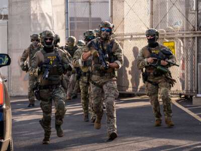 Immigration and Customs Enforcement (ICE) agents run out of Delaney Hall Immigration Detention Center as they protect vehicles during a shift change on June 7, 2026 in Newark, New Jersey.