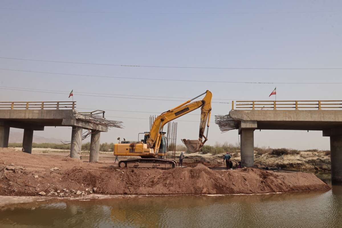 An excavator works on the Gachin Bridge, which was damaged by a UsSs strike, along the road between Bandar Abbas and Bandar Khamir, southern Iran on August 11, 2026.