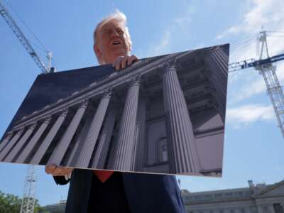 President Donald Trump holds artists renderings as he talks to reporters about his proposed White House ballroom next to the worksite on May 19, 2026 in Washington, D.C.
