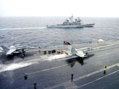 The USS Phillipine Sea Steams Off The Port Side Of The USS Enterprise, While An F/A-18C "Hornet" Launches From The Flight Deck At Adriatic Sea On February 25, 1999. Events In The Yugoslavian Province Of Kosovo Have Placed The Enterprise In A High State Of Alert Pending Possible U.S. And Nato Led Air Strikes.