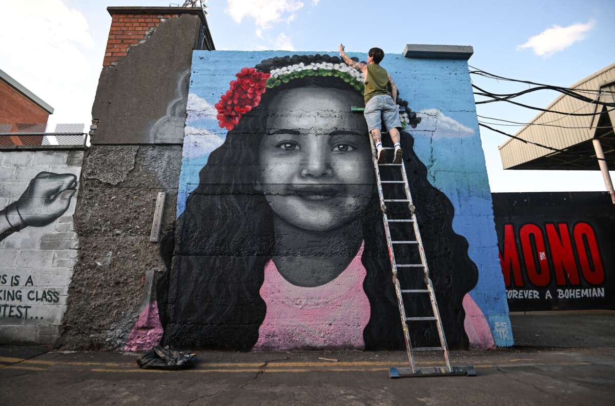 Artist Emmalene Blake puts the final touches to a mural of Hind Rajab, the 6-year-old Palestinian girl who was killed in Gaza, along with several family members and paramedics.