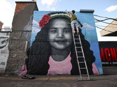 Artist Emmalene Blake puts the final touches to a mural of Hind Rajab, the 6-year-old Palestinian girl who was killed in Gaza, along with several family members and paramedics.