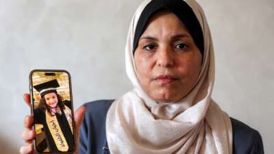 The grandmother of Hind Rajab holds a mobile phone displaying a picture of Hind on August 20, 2026.
