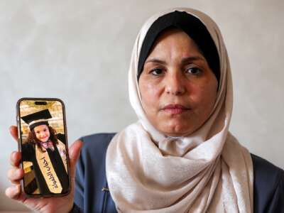 The grandmother of Hind Rajab holds a mobile phone displaying a picture of Hind on August 20, 2026.