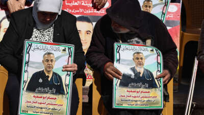 People lift placards bearing portraits of Palestinians currently detained by Israel, including the director of the Kamal Adwan Hospital in Gaza Dr. Hussam Abu Safiya, during a protest in solidarity with them in Ramallah city in the occupied West Bank, on January 14, 2025.