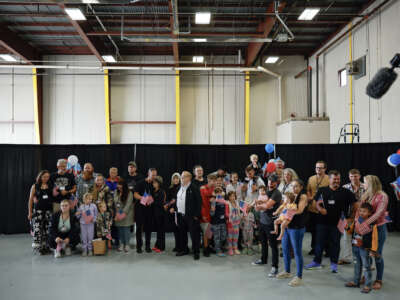 Newly arrived Afrikaners wait to hear welcome statements from U.S. government officials in a hangar at Atlantic Aviation near Washington Dulles International Airport on May 12, 2025, in Dulles, Virginia.