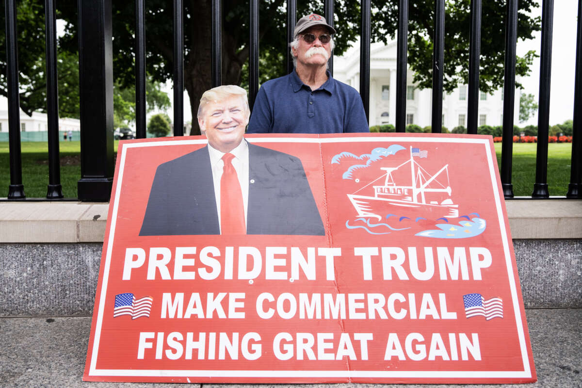 A person displays a commercial fishing sign outside the White House in Washington, D.C., on May 16, 2025.