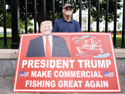 A person displays a commercial fishing sign outside the White House in Washington, D.C., on May 16, 2025.
