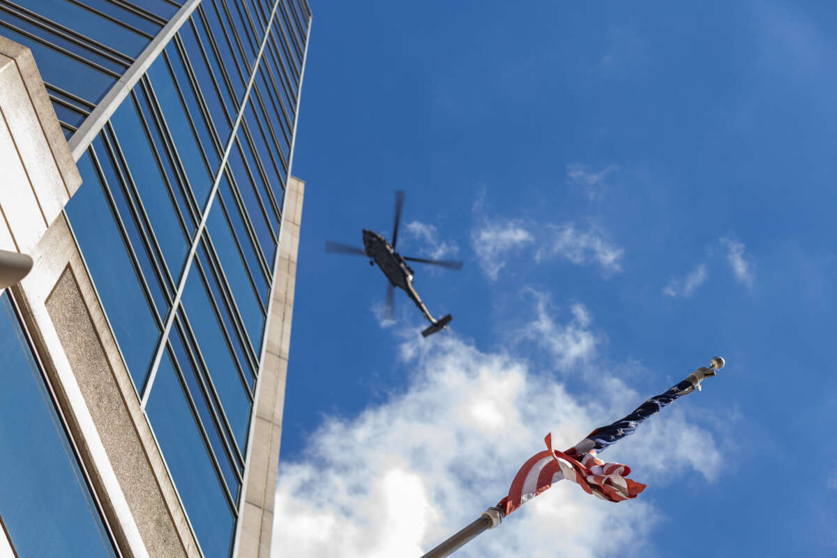 A US flag is seen as a police helicopter circles a protest march through downtown Memphis, Tennessee, in opposition to the increase of federal law enforcement agents, the coming deployment of the National Guard and xAI, an AI company owned by Elon Musk that is locally based, during the "Get Out of Memphis" protest on October 4, 2025.