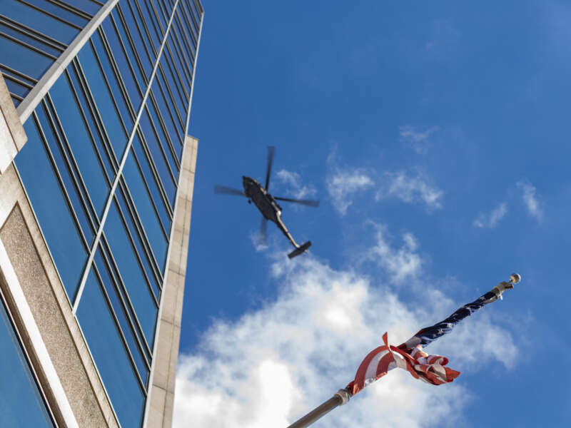 A US flag is seen as a police helicopter circles a protest march through downtown Memphis, Tennessee, in opposition to the increase of federal law enforcement agents, the coming deployment of the National Guard and xAI, an AI company owned by Elon Musk that is locally based, during the "Get Out of Memphis" protest on October 4, 2025.