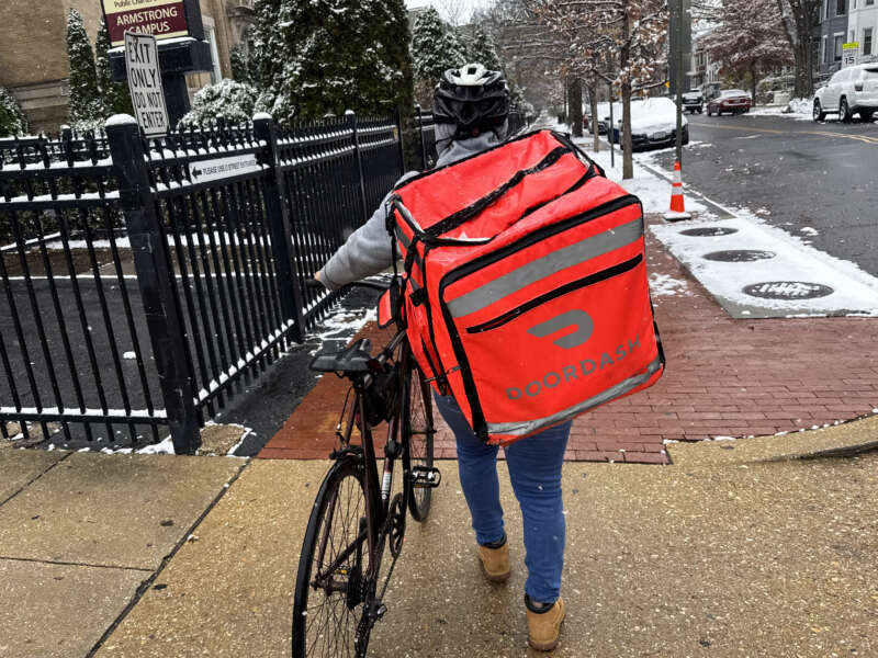 A DoorDash delivery person is seen in the Truxton Circle neighborhood of Washington, D.C., on December 5, 2025.