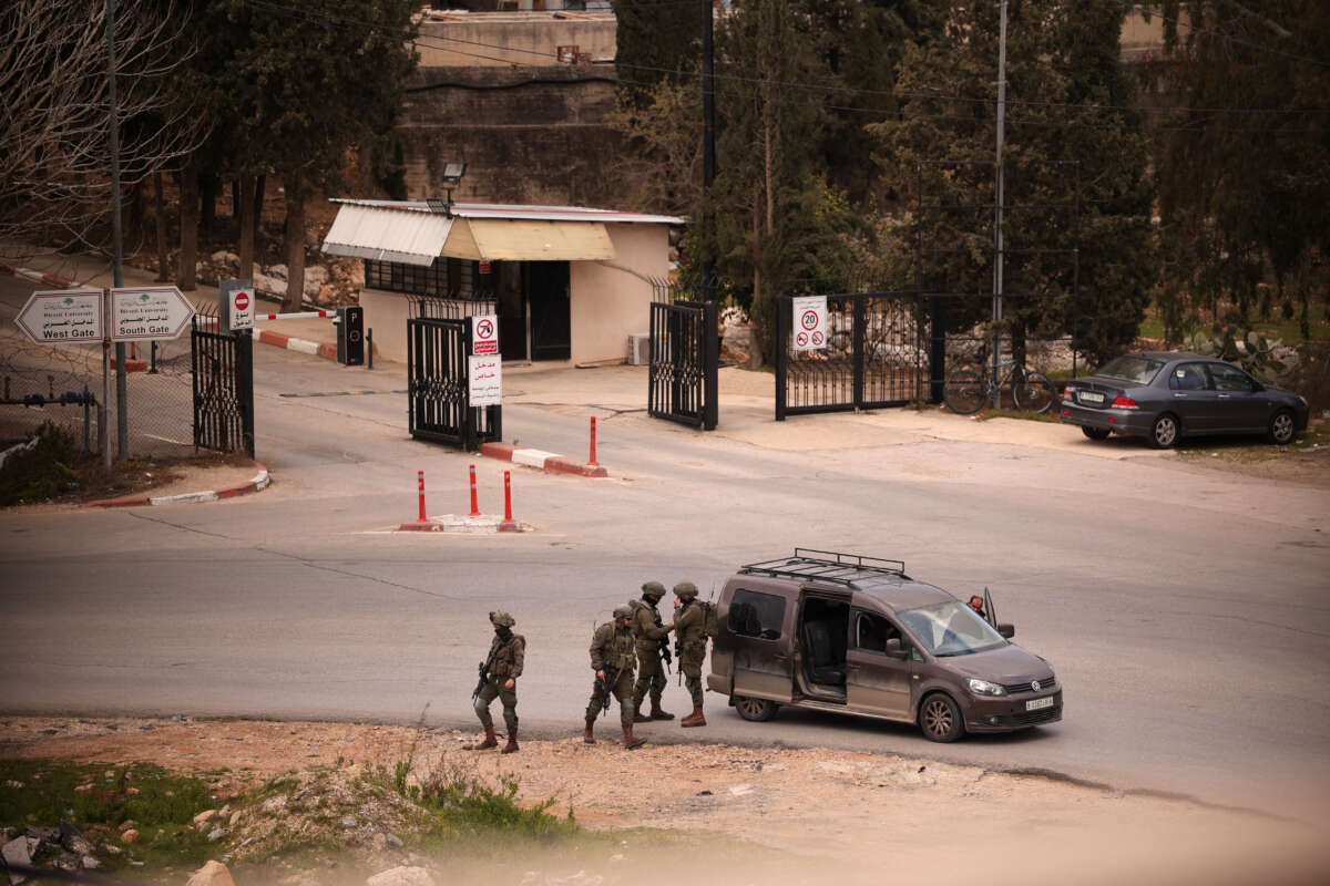 Israeli soldiers stop and inspect a Palestinian vehicle at a temporary checkpoint near the entrance to Birzeit University, north of Ramallah, in the occupied West Bank, on February 23, 2026.