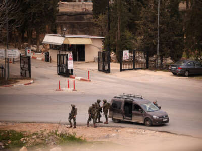 Israeli soldiers stop and inspect a Palestinian vehicle at a temporary checkpoint near the entrance to Birzeit University, north of Ramallah, in the occupied West Bank, on February 23, 2026.