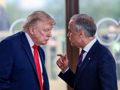 U.S. President Donald Trump speaks with Canada's Prime Minister Mark Carney during a work lunch as part of the G7 summit, in Evian, eastern France, on June 16, 2026.