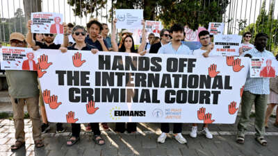 People take part in a demonstration in defense of the International Criminal Court, holding banners reading "Hands off the International Criminal Court" and placards depicting Donald Trump, Vladimir Putin, and Ursula von der Leyen, at Piazza Ugo La Malfa, on July 16, 2026 in Rome, Italy.