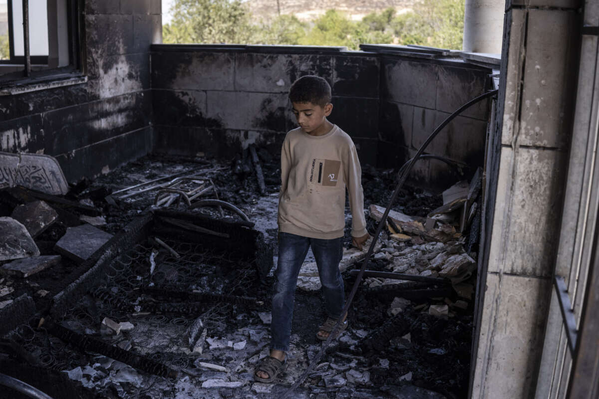 A young Palestinian boy is seen at a mosque allegedly burned by Israeli settlers in the village of Qusra, south of Nablus in the Israeli-occupied West Bank, on July 26, 2026.
