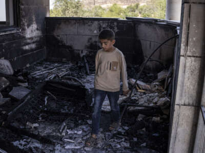 A young Palestinian boy is seen at a mosque allegedly burned by Israeli settlers in the village of Qusra, south of Nablus in the Israeli-occupied West Bank, on July 26, 2026.