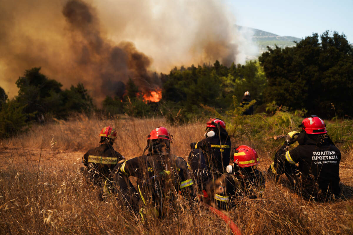 Firefighters and Hellenic Civil Protection personnel battle advancing flames during a wildfire near Agios Nektarios in Western Attica, Greece, as firefighting operations continue under difficult conditions on August 2, 2026.