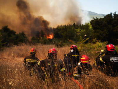 Firefighters and Hellenic Civil Protection personnel battle advancing flames during a wildfire near Agios Nektarios in Western Attica, Greece, as firefighting operations continue under difficult conditions on August 2, 2026.