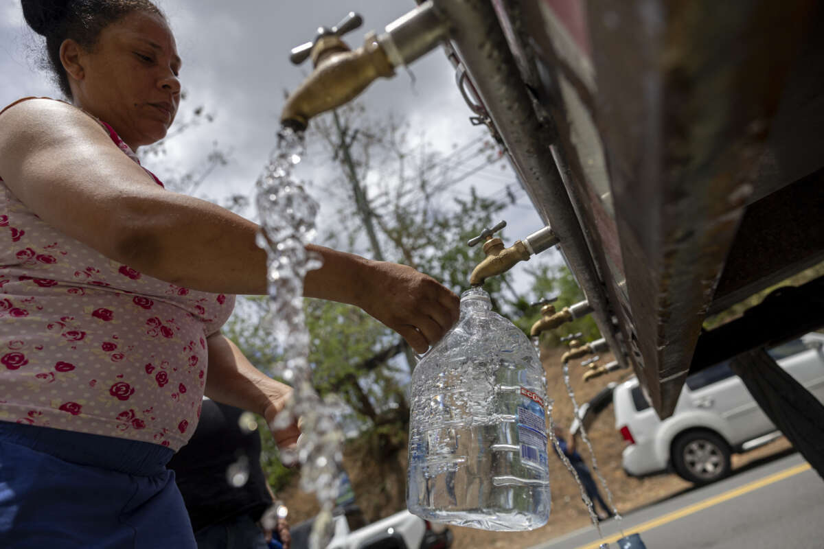 A resident collects water from a tanker truck at a distribution point during a government imposed water rationing amid a severe drought in San Juan, Puerto Rico, on August 6, 2026.