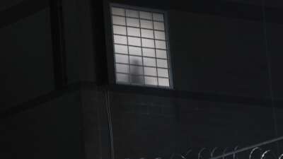 A detainee is silhouetted in a window as protesters gather outside the federal immigration center at Delaney Hall where ICE is housing detained immigrants on June 8, 2026, in Newark, New Jersey.