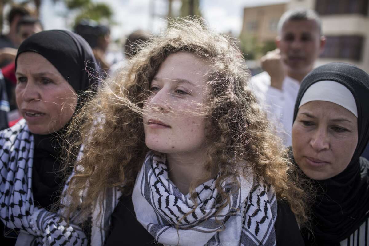 Palestinian activist Ahed Tamimi (center) arrives for a press conference with her mother Nariman (right) after her release from an Israeli prison where she served a sentence of eight months for slapping an Israeli soldier in her hometown of Nabi Saleh, West Bank, on July 29, 2018.