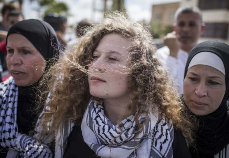 Palestinian activist Ahed Tamimi (center) arrives for a press conference with her mother Nariman (right) after her release from an Israeli prison where she served a sentence of eight months for slapping an Israeli soldier in her hometown of Nabi Saleh, West Bank, on July 29, 2018.