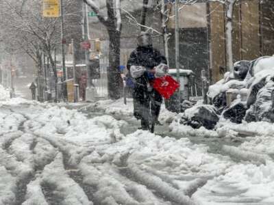 A Doordash delivery driver moves through the blowing snow in Manhattan as a large winter storm makes its way across the area on February 13, 2024, in New York City.