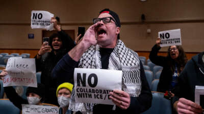 Anti-ICE and Border Patrol protestors disrupt a city council meeting before being removed by New Orleans Police Department officers at City Hall in New Orleans, Louisiana, on December 4, 2025.
