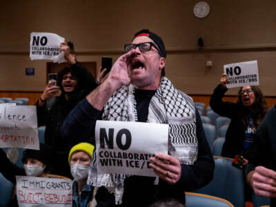 Anti-ICE and Border Patrol protestors disrupt a city council meeting before being removed by New Orleans Police Department officers at City Hall in New Orleans, Louisiana, on December 4, 2025.