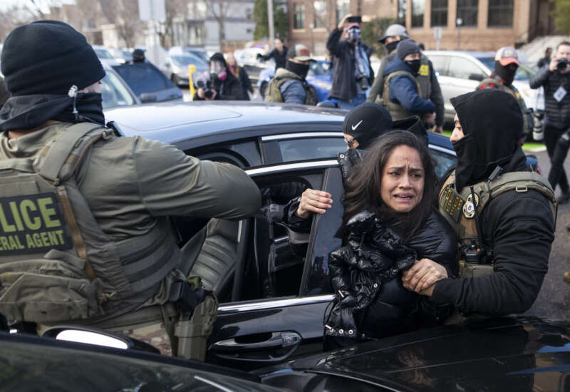 ICE agents detain a woman after pulling her from a car on January 13, 2026, in Minneapolis, Minnesota.