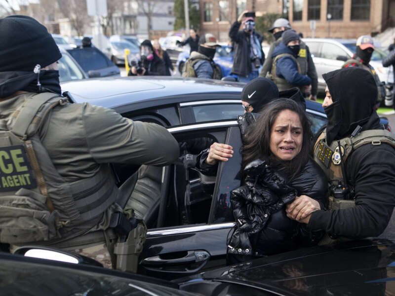 ICE agents detain a woman after pulling her from a car on January 13, 2026, in Minneapolis, Minnesota.