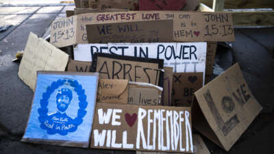 Signs sit in a pile at a memorial for Alex Pretti, who was shot and killed by an ICE agent, on February 12, 2026, in Minneapolis, Minnesota.