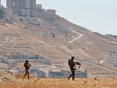 Israeli soldiers walk through an open field in Beit Sahour, south of Bethlehem, in the occupied West Bank on August 14, 2026. Violence against Palestinians by Israeli settlers in the West Bank has increased dramatically since October 7, 2023.