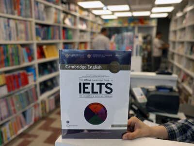 A bookstore employee displays an International English Language Testing System (IELTS) book in Tehran, Iran, on September 7, 2026. Testing has been suspended in Iran since September 1 following the latest U.S. sanctions.